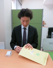 写真:小野さんが名刺を封筒に入れてます